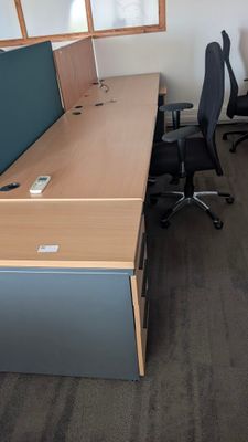 a desk with a monitor and a chair in a room