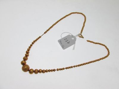 gold beaded necklace with a tag on a white background