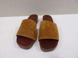 a close up of a pair of brown sandals on a white surface
