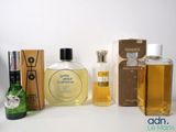 several bottles of perfume sitting on top of a table next to a box