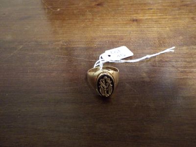 une bague en or avec une image gravée dessus, posée sur une table