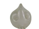 une sculpture en verre représentant un visage sur fond blanc