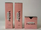 three boxes of prada perfume on a white surface