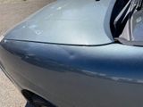 a close up of a car ' s front bumper with a broken windshield