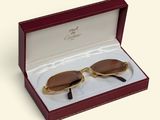 pair of brown sunglasses in a red box on a white surface