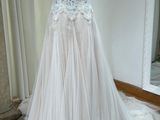 une robe de mariée posée sur un mannequin devant un miroir