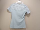 the top of a blue shirt with white lace is hanging on a hanger