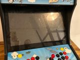 an arcade machine sitting on top of a wooden table
