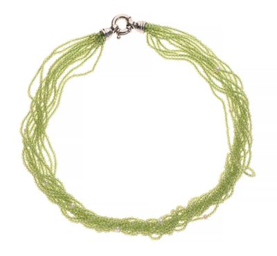 gros plan d'un collier de perles vertes sur fond blanc