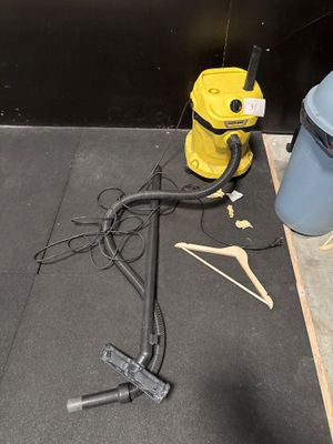 un aspirateur jaune et un seau bleu posés par terre