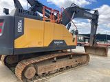 the back end of a yellow and black excavator sitting on top of a parking lot