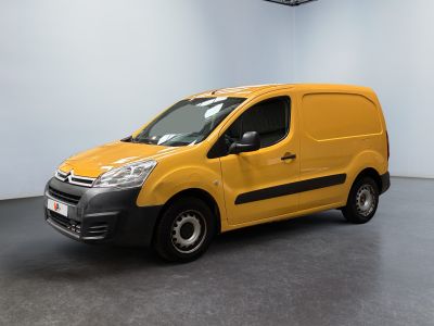 La camionnette jaune est garée dans une pièce blanche au sol noir.