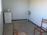 two chairs and a table in a room with a fan