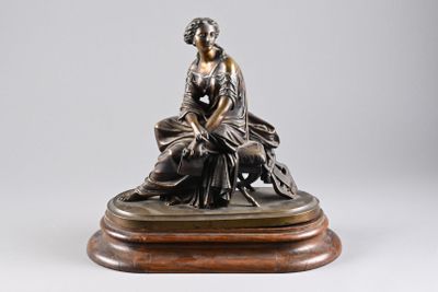 bronze statue of a woman sitting on a rock with a dog