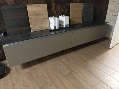 un parquet en bois massif dans un salon équipé d'un meuble TV à plateau en verre
