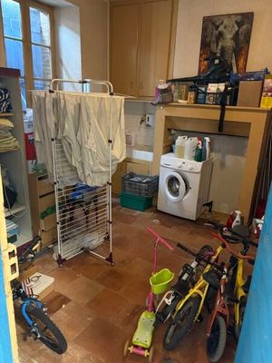 une buanderie équipée d'un lave-linge et d'un vélo
