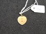a gold heart shaped tag on a black surface