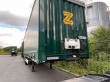 a truck that is driving down the road next to a car