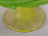 un vase jaune contenant une feuille verte