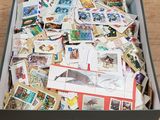 une boîte remplie de timbres et de cartes postales posée sur une table