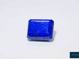 une pierre de lapis carrée, présentant des mouchetures bleues sur une surface blanche