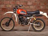 a red and white dirt bike parked in front of a brick wall