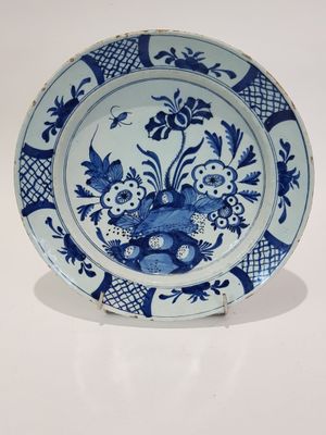 une assiette bleue et blanche ornée de fleurs et d'oiseaux