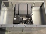 an overhead view of a metal box with a suitcase in it