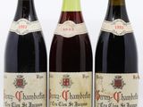 trois bouteilles de vin sont alignées sur une surface blanche