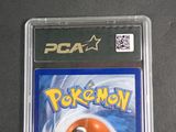 a pokemon card in a plastic case on a table