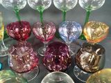 many different colored wine glasses sitting on a table