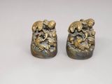 paire de figurines en bronze représentant un garçon et une fille assis sur un rocher