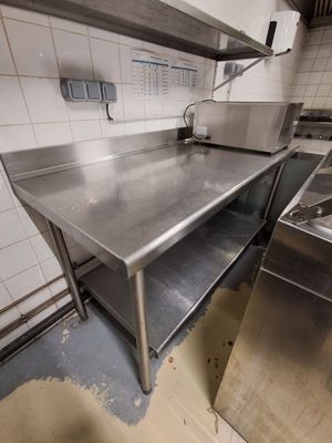 une grande cuisine en inox équipée d'un évier et d'une cuisinière