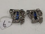 une paire de boucles d'oreilles « Rhine » bleues et blanches posées sur un fond blanc