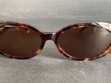brown tortoise sunglasses with brown lenses on a gray surface