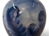 a blue vase that has a leaf design on it