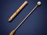 un bâtonnet doré et nacré, ainsi qu'une boule nacrée, sur fond bleu