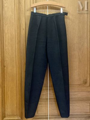 le pantalon est suspendu à un cintre devant une porte en bois
