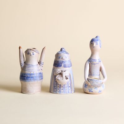 trois figurines en céramique assises les unes à côté des autres