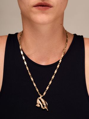 une femme vêtue d'un débardeur noir et portant un collier en or