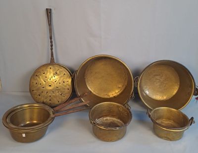 beaucoup de casseroles et poêles en or posées sur une table