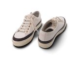 une paire de baskets blanches posées sur une surface blanche, avec un fond blanc
