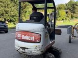 a man driving a small tractor in a parking lot