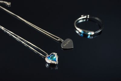 deux colliers et une bague avec un cœur sur fond noir