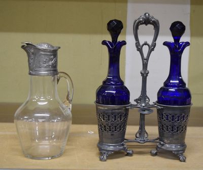 trois vases en verre bleu et un vase en argent posés sur une table