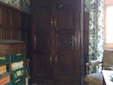 une grande armoire en bois dans une pièce au papier peint à motifs floraux