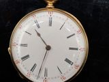 une montre de poche en or avec des chiffres romains sur le cadran