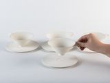 une personne qui tient une cuillère et quelques tasses