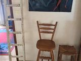 une échelle appuyée contre le mur, à côté d'une chaise