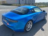 une photo d'une voiture de sport bleue garée sur un parking